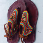 Pair of sandals with colorful beaded straps on a white background