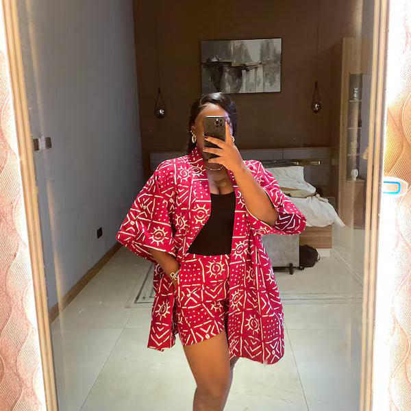 Person wearing a red and white patterned outfit taking a mirror selfie.