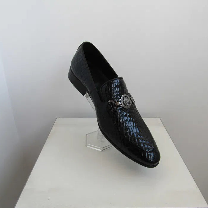 Black textured loafers on a white pedestal against a light gray background
