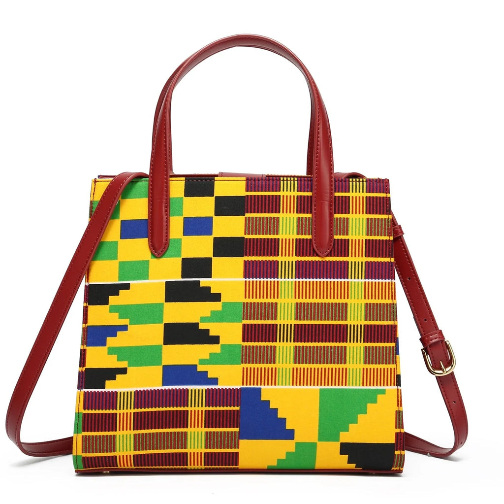 Colorful patterned handbag with brown handles and strap on a white background