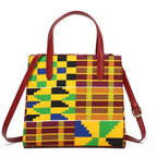 Colorful patterned handbag with brown handles and strap on a white background
