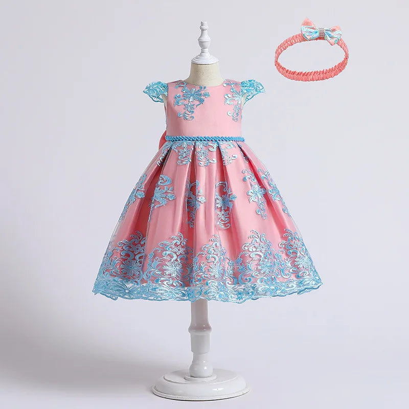 Pink dress with blue floral patterns on a mannequin, accompanied by a matching headband.