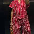 Person wearing a red and white patterned outfit with a black background