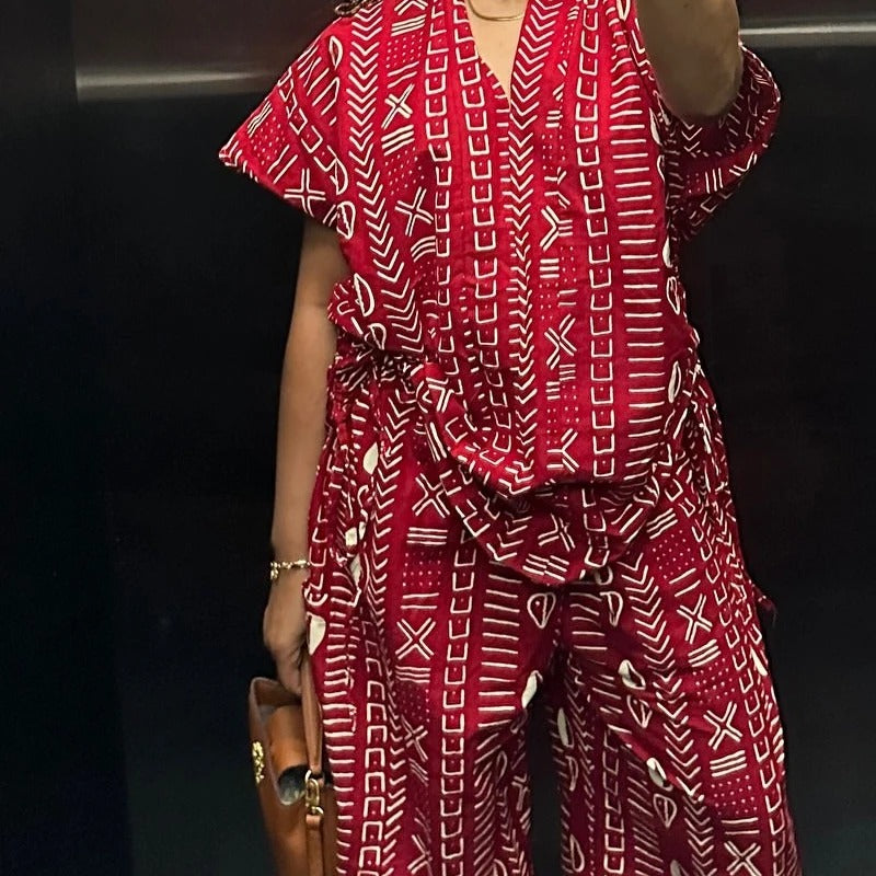 Person wearing a red and white patterned outfit with a black background