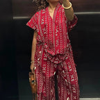 Person wearing a red patterned jumpsuit in an elevator.