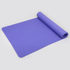 Purple yoga mat rolled up on a light gray background