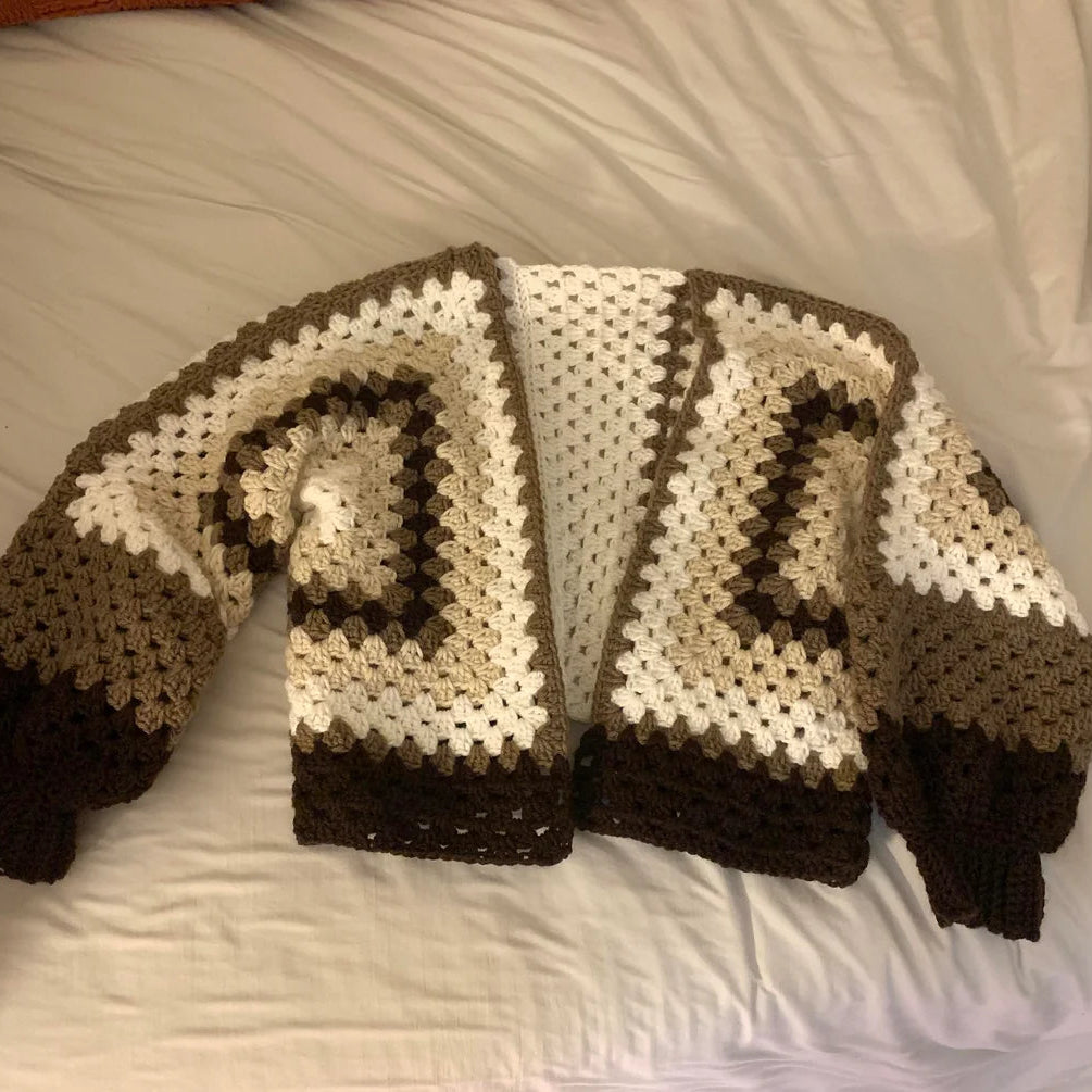 Crocheted sweater with brown and white pattern on a bed